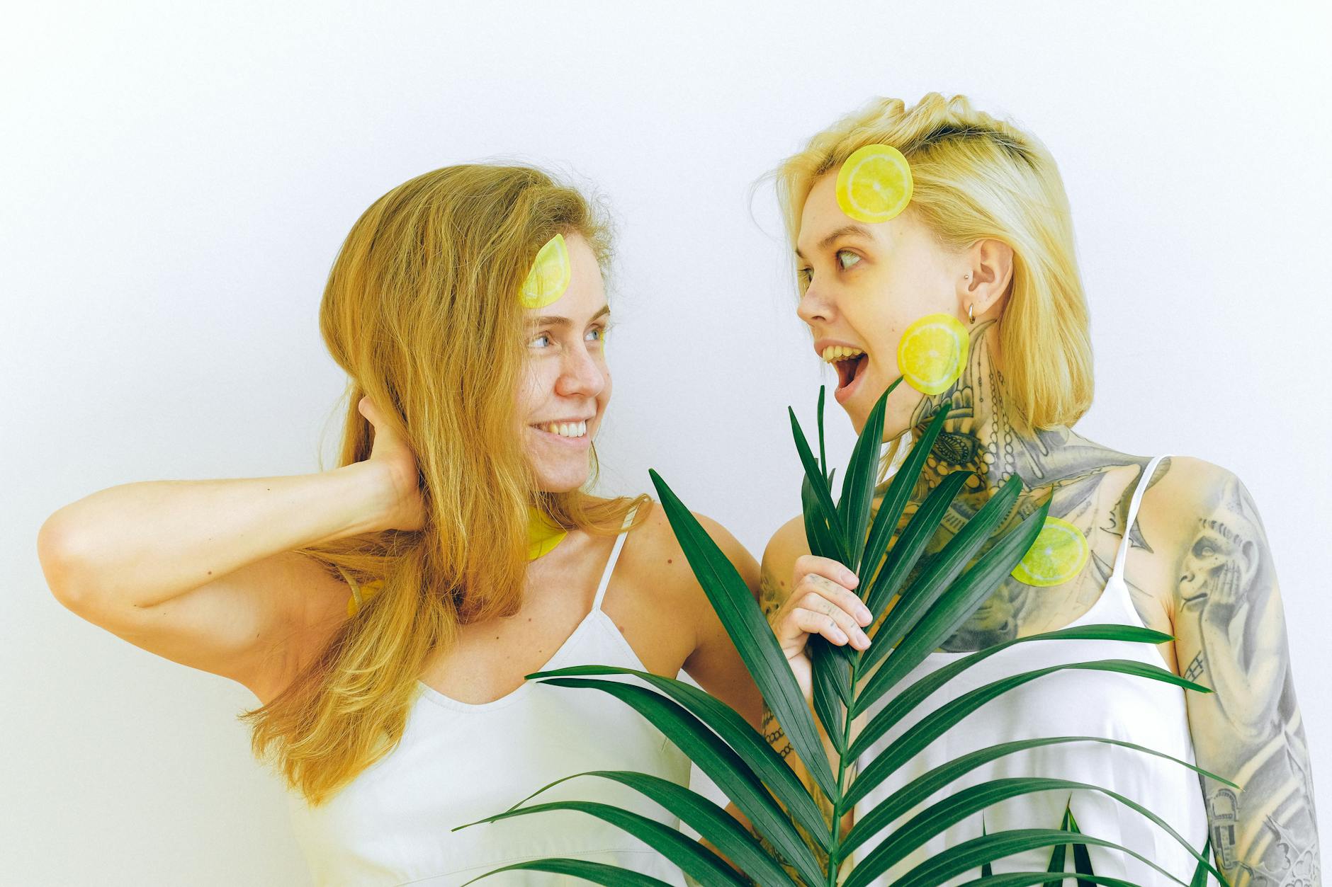 Twee lachende vrouwen die citrusvruchten houden en vreugde uitdrukken