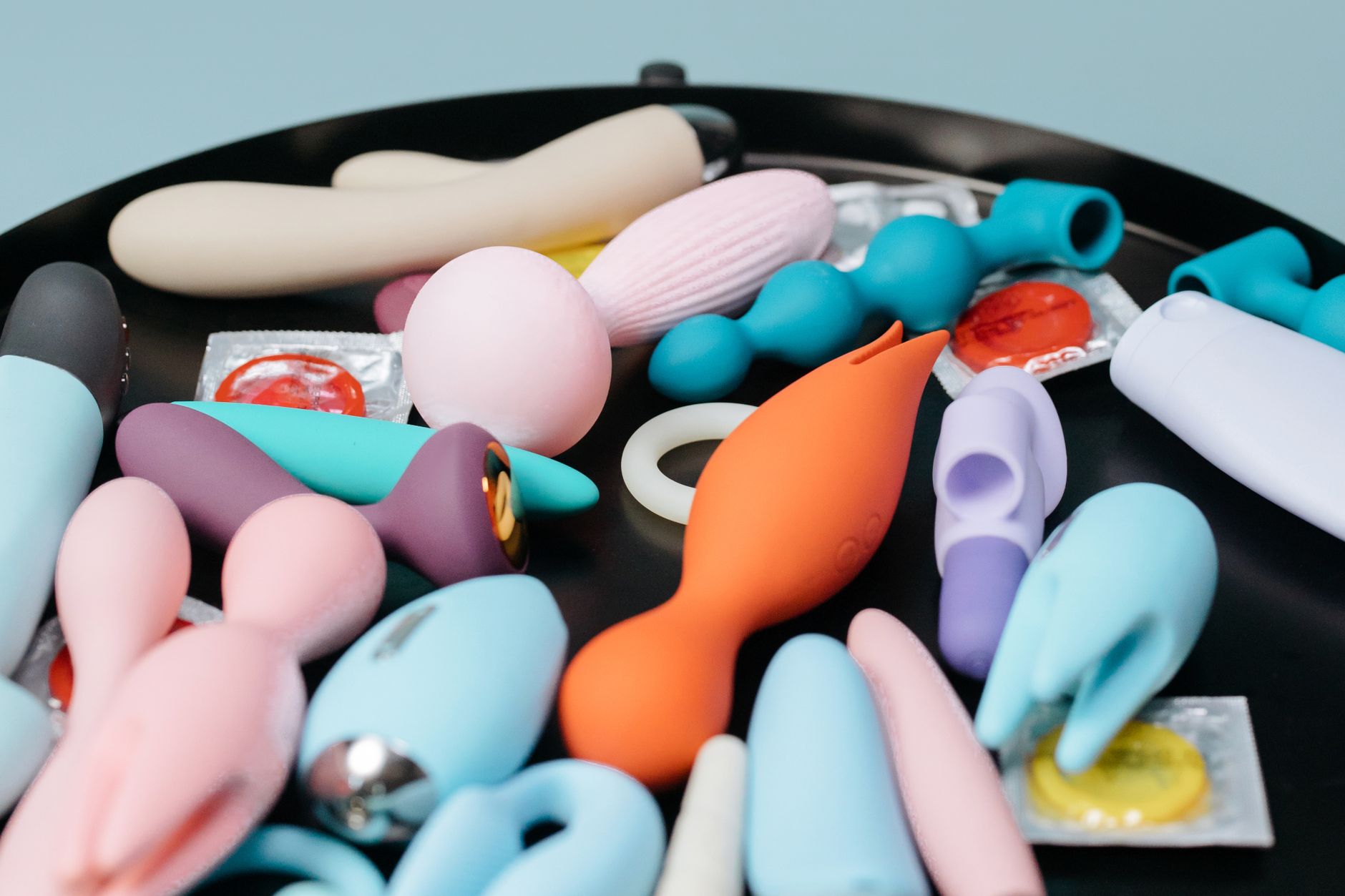 Handen houdend een blauwe personal massager tegen een gebreide trui