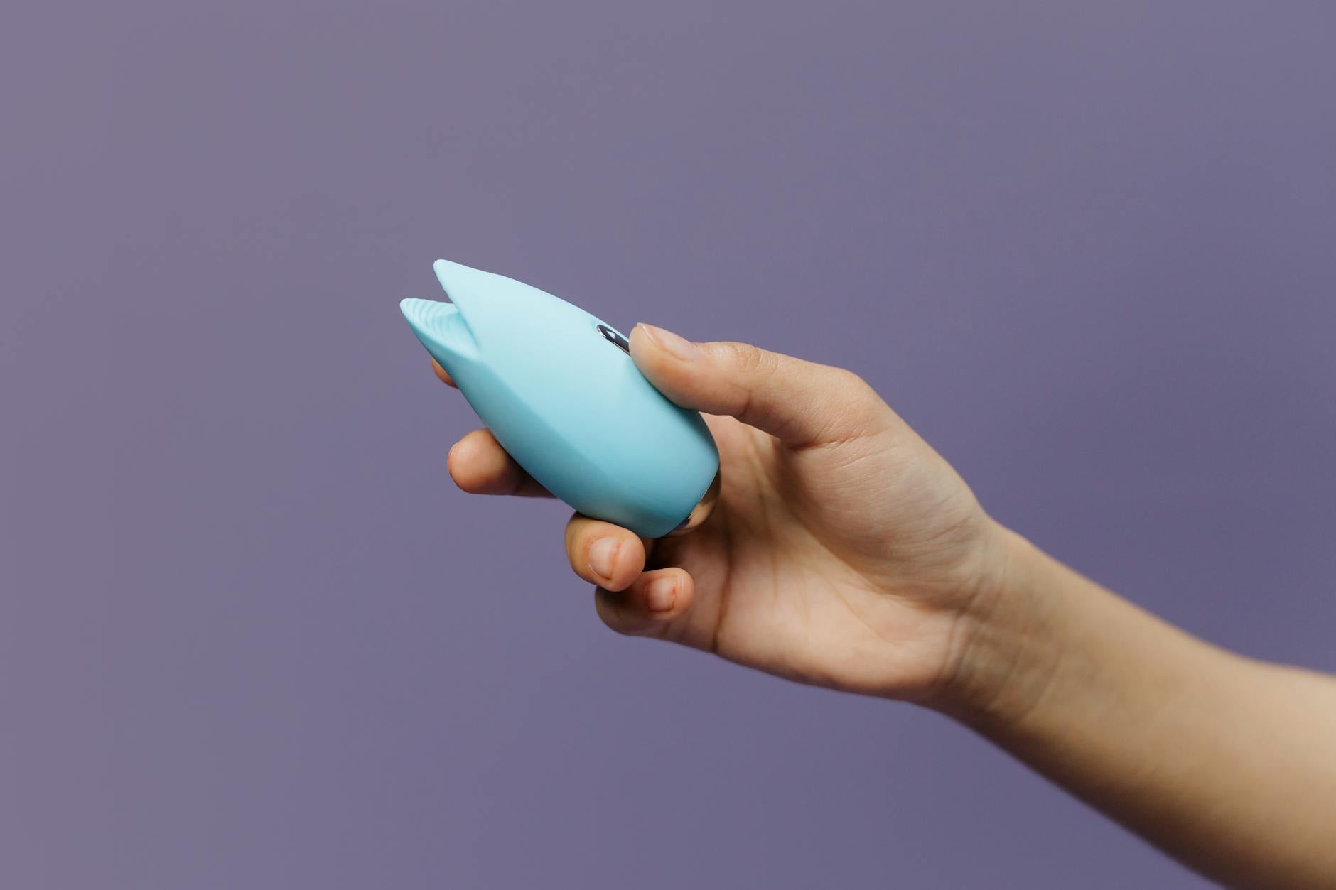 Twee vrouwen houden blauw en roze siliconen vibrators in een contemplatieve houding
